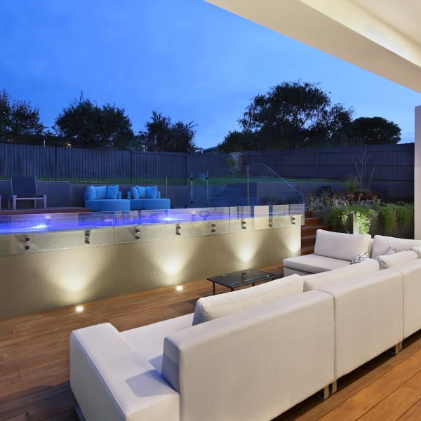 designer outdoor area with timber decking and feature lighting